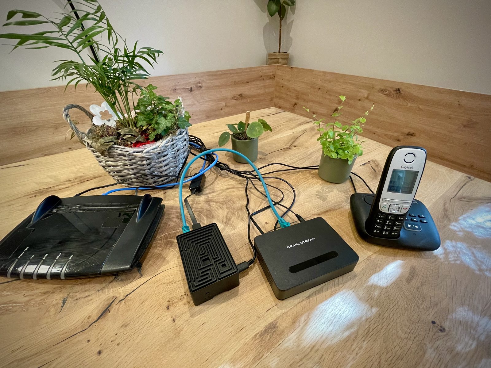 Der Circura Wächter angeschlossen: Router, die beiden Geräte und das Festnetztelefon auf einem Tisch